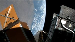 Umelecká vizualizácia satelitov typu cubesat na obežnej dráhe Zeme upevnených na adaptéri.