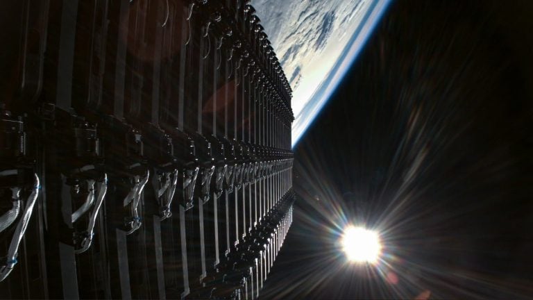 Satelity Starlink zoradené na obežnej dráhe na pozadí zakrivenia Zeme